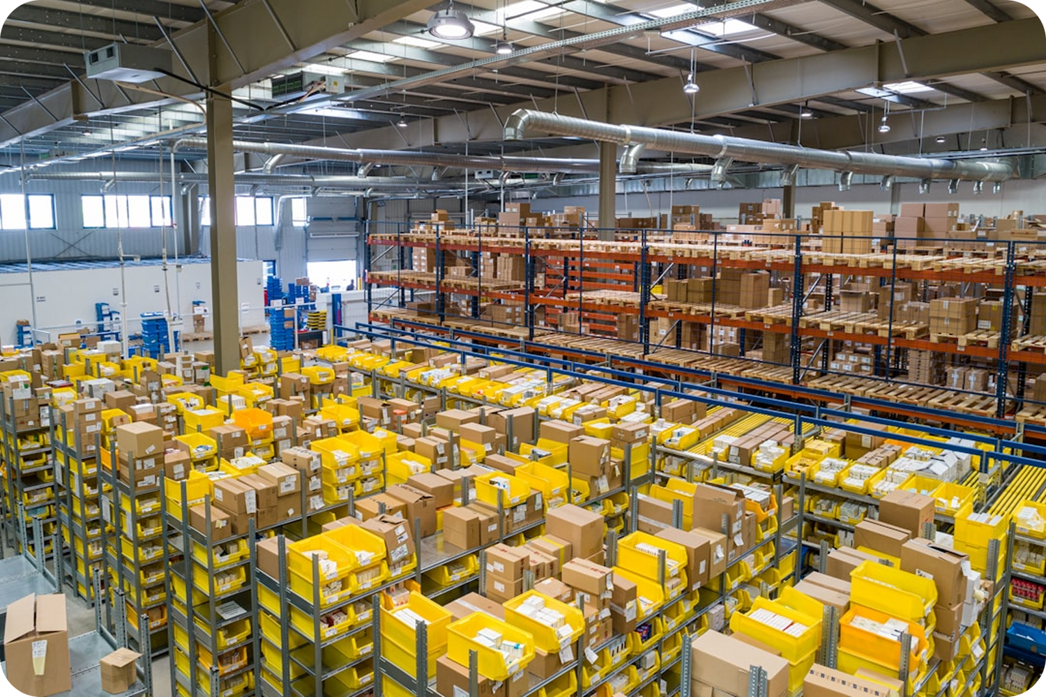 Large warehouse with shelves and pallets filled with boxes and yellow packages.