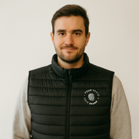 Model wearing custom branded black padded puffer vest with company logo on chest
