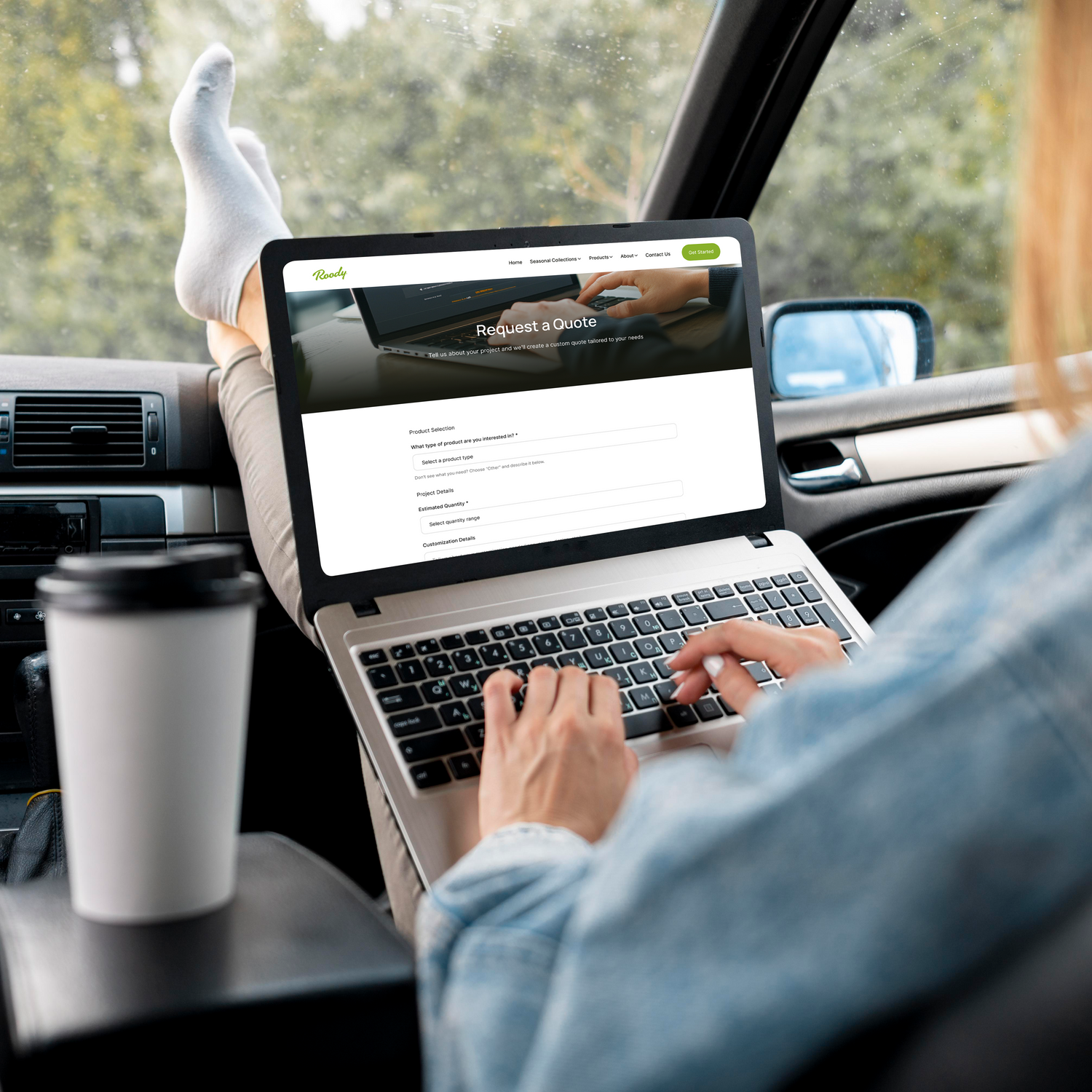 Person using a laptop in a car with a website open on the screen.